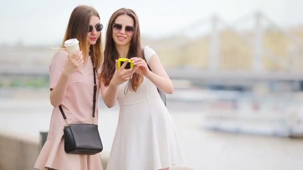 Hermanas jóvenes positivas divirtiéndose y haciendo selfie. Concepto de amistad y diversión con nuevas tendencias y tecnología. Mejores amigos salvando el momento con su cámara amarilla — Vídeo de stock