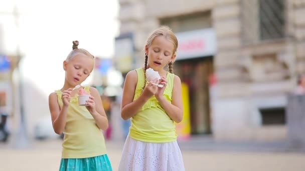 Söta små flickor som äter glass utomhus på sommaren. Söta barn njuter av äkta italiensk gelato nära Gelateria i Rom — Stockvideo