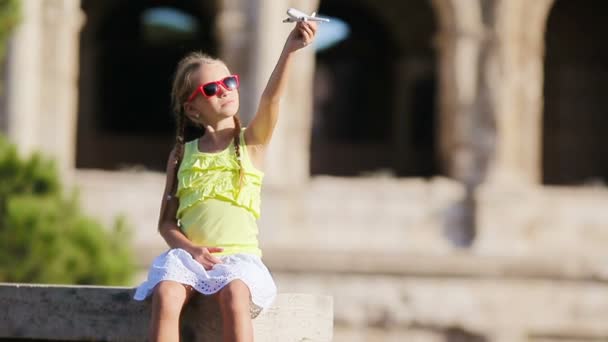 Schattig meisje met klein speelgoed model vliegtuig achtergrond Colosseum in Rome, Italië — Stockvideo