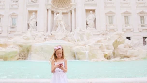 Adorabile bambina con cellulare in una calda giornata all'aria aperta nella città europea vicino alla famosa Fontana di Trevi — Video Stock