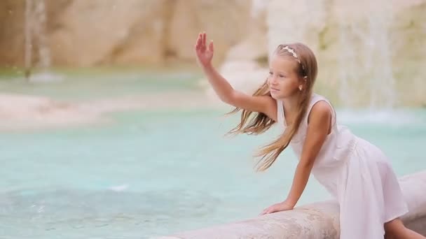 Αξιολάτρευτο κοριτσάκι κοντά στο συντριβάνι του Τρέβι στη Ρώμη. Ευτυχισμένο παιδί απολαμβάνουν τις διακοπές τους στην Ευρώπη στην Ιταλία — Αρχείο Βίντεο