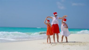 Noel tatilinde Noel Baba şapkalı küçük kızlar ve genç anneler