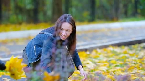 Las niñas y las madres felices disfrutan del día de otoño en el parque de otoño al aire libre. Vacaciones familiares de otoño — Vídeos de Stock