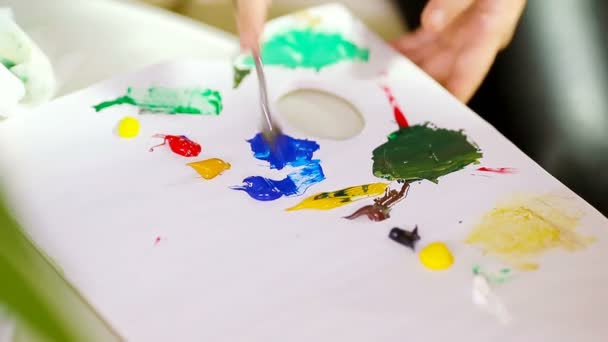 Imádnivaló kislány festeni egy képet festőállvány beltéri — Stock videók