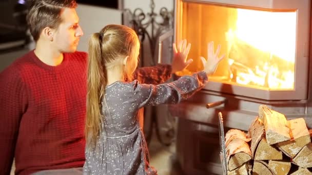 Family sitting by a fireplace in their family home on Christmas — Stock Video