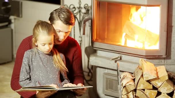 Famille assise près d'une cheminée dans leur maison familiale à Noël — Video