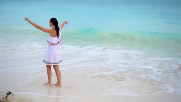 Jonge mooie vrouw aan de tropische kust. Boven uitzicht op gelukkig meisje in mooie jurk op wit strand — Stockvideo