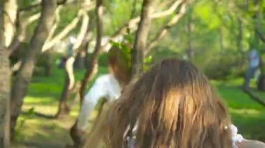 Çiçek açan elma bahçesindeki tatlı kızlar sıcak günün tadını çıkarın.