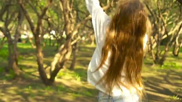 Aranyos lányok a virágzó almafa kertben élvezze a meleg napot — Stock videók