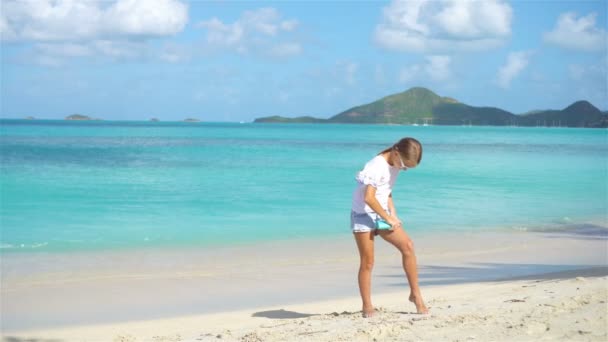 Menina adorável na praia tropical aplicando creme protetor solar — Vídeo de Stock