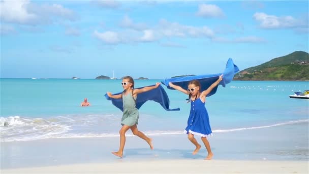 小さな女の子は熱帯の休暇中にビーチタオルで楽しみを持っています — ストック動画