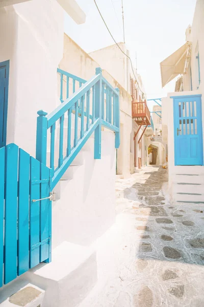 Las estrechas calles de la isla con balcones azules, escaleras y flores . —  Fotos de Stock