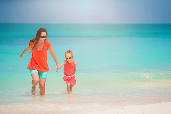 Beautiful mother and daughter on the beach enjoying summer vacation — Stock Photo, Image