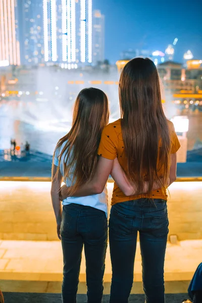 Little girls watch the legendary show of singing fountains in Dubai — стокове фото