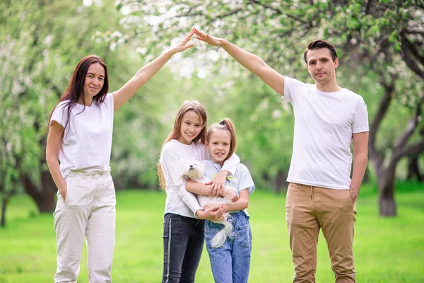 Adorável família no jardim florescendo cereja no belo dia de primavera — Fotografia de Stock