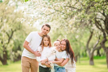 Güzel bir bahar gününde kiraz bahçesinde sevimli bir aile.