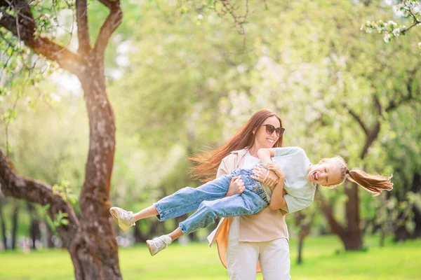 Família de mãe e filha no jardim de cereja florescente — Fotografia de Stock