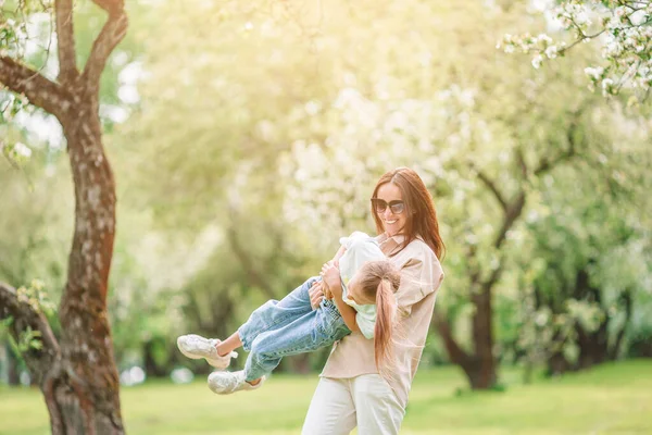 Familia de madre e hija en floreciente jardín de cerezos —  Fotos de Stock