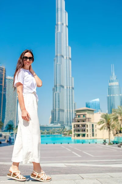 Dubai 'de arka planda gökdelenle yürüyen mutlu bir kadın..