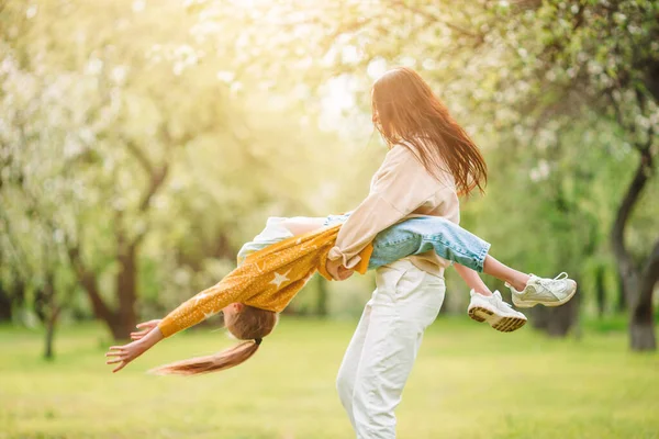 Familia de madre e hija en floreciente jardín de cerezos —  Fotos de Stock