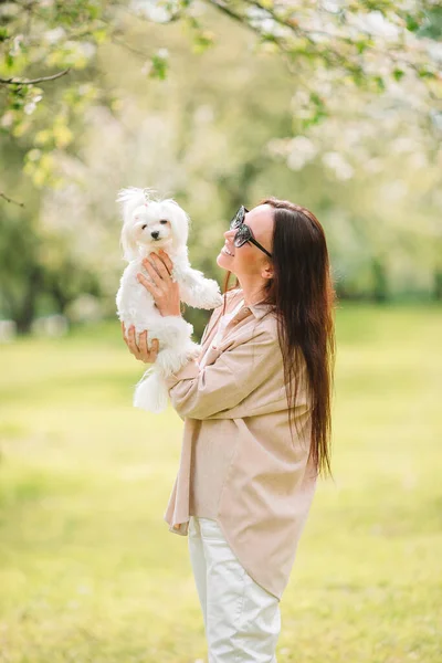 Frau spielt und umarmt Welpen im Park — Stockfoto