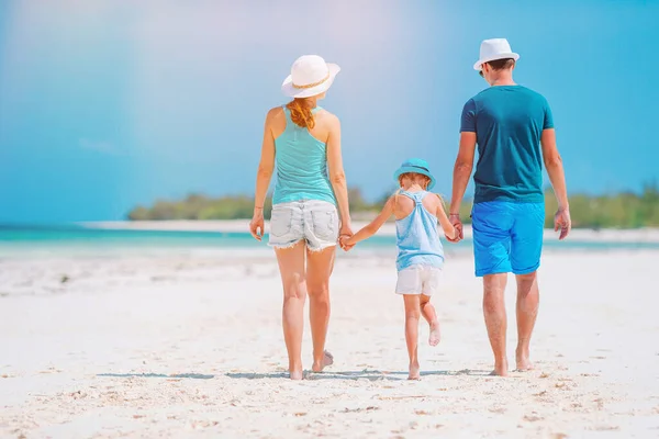 Молодая семья на белом пляже во время летних каникул — стоковое фото