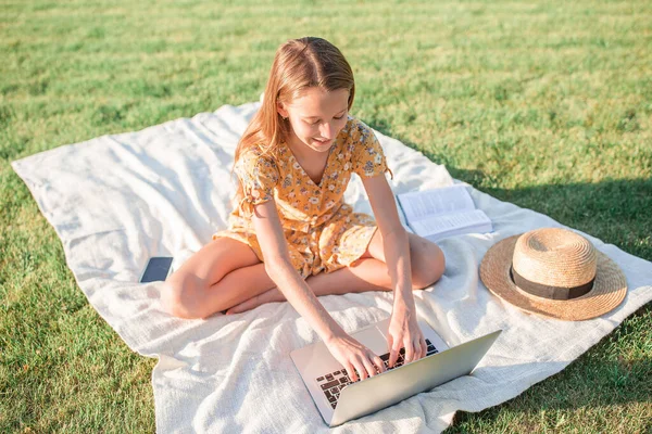 Petite fille en plein air dans le parc avec ordinateur — Photo