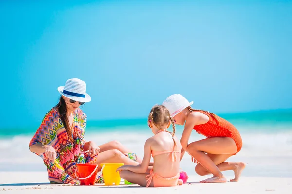 Vierköpfige Familie baut Sandburg am tropischen weißen Strand — Stockfoto