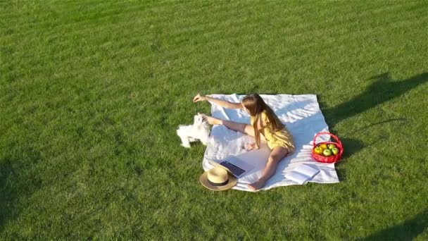 Niña sonriente jugando con el cachorro en el parque — Vídeo de stock