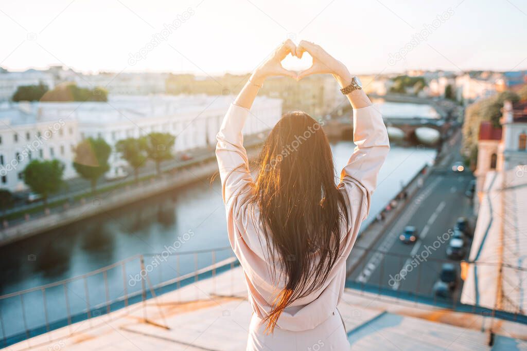 Woman on rooftop enjoying with view of beautiful sunset in Sankt Petersburg in Russia