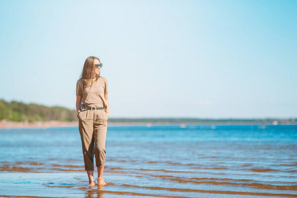 Молодая красивая женщина веселится на тропическом побережье.