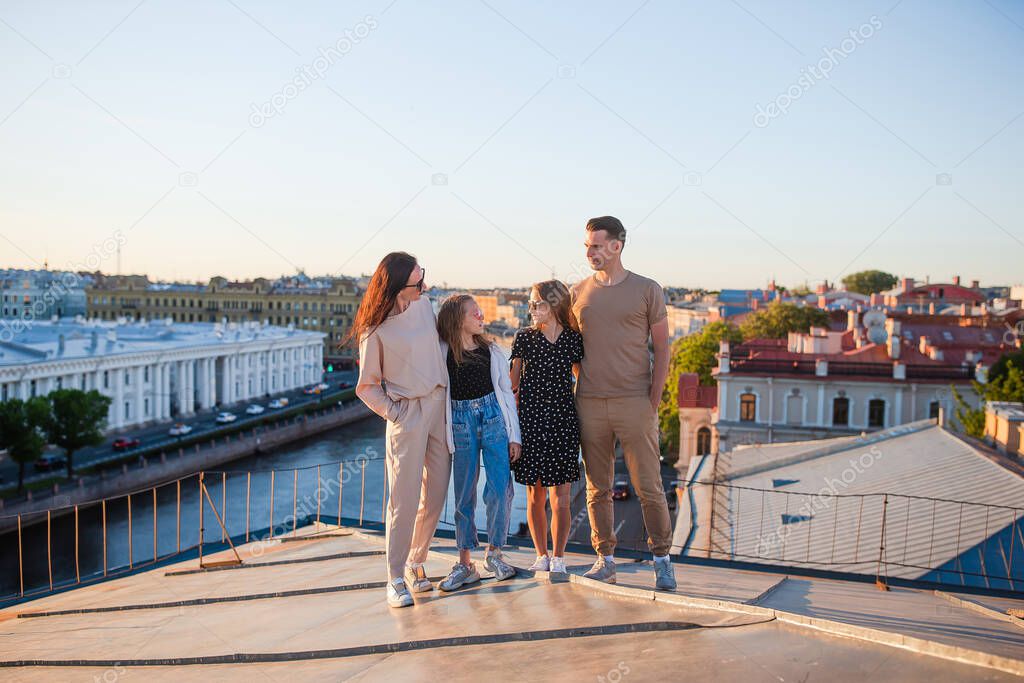 Family on rooftop enjoying with view of beautiful sunset in Sankt Petersburg in Russia