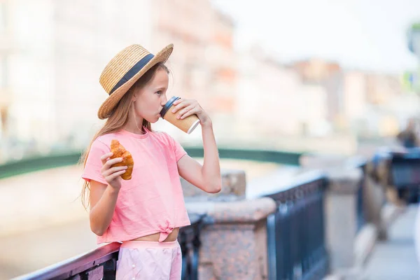 Žena s croissantem a kávou venku na promenádě — Stock fotografie