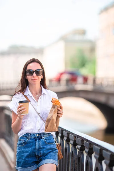 Femme avec un croissant et café en plein air sur la promenade — Photo