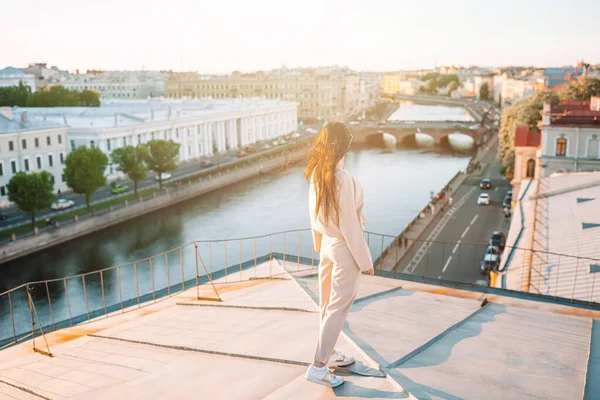 Vrouw op het dak genietend van het uitzicht op de prachtige zonsondergang in Sankt Petersburg in Rusland — Stockfoto