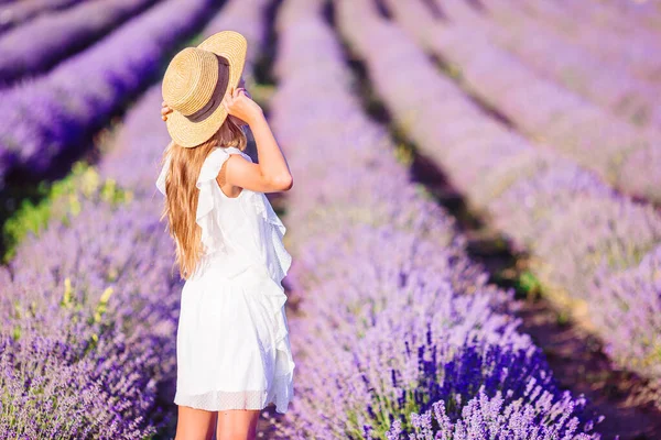 Femme au champ de fleurs de lavande au coucher du soleil en robe blanche et chapeau — Photo