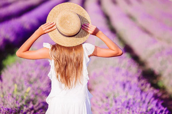 Femme au champ de fleurs de lavande au coucher du soleil en robe blanche et chapeau — Photo