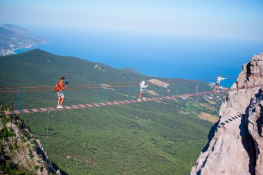 Baba ve çocukların ailesi, Kırım 'daki Simeiz' de Karadeniz üzerinde asma köprüde..