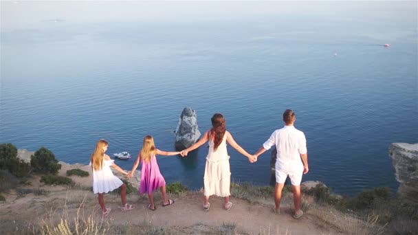 Família feliz de quatro caminhando nas montanhas ao pôr do sol — Vídeo de Stock