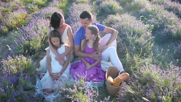Familia en el campo de flores de lavanda al atardecer en vestido blanco y sombrero — Vídeos de Stock