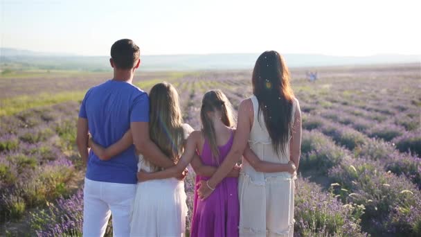 Сім'я на полі квітів лаванди на заході сонця — стокове відео