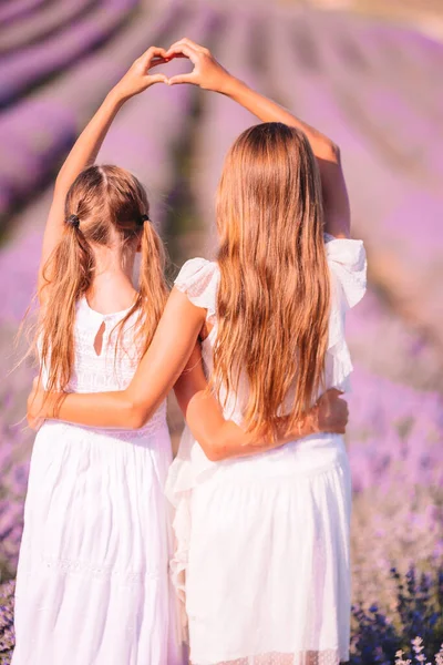 Meninas no campo de flores de lavanda ao pôr do sol em vestido branco — Fotografia de Stock