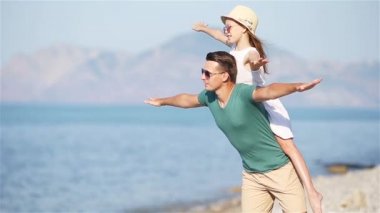 Küçük kız ve mutlu baba kumsal tatili boyunca eğleniyorlar.