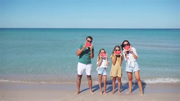 Feliz familia comiendo sandía en la playa. — Vídeo de stock