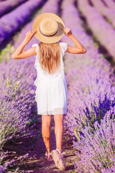 Femme au champ de fleurs de lavande au coucher du soleil en robe blanche et chapeau — Photo