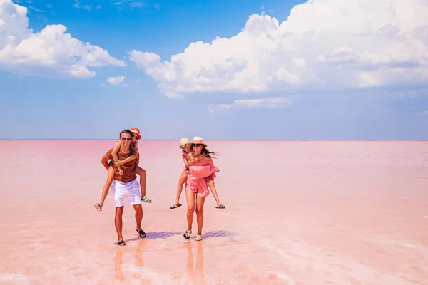 Family walk on a pink salt lake on a sunny summer day. — Stock Photo, Image