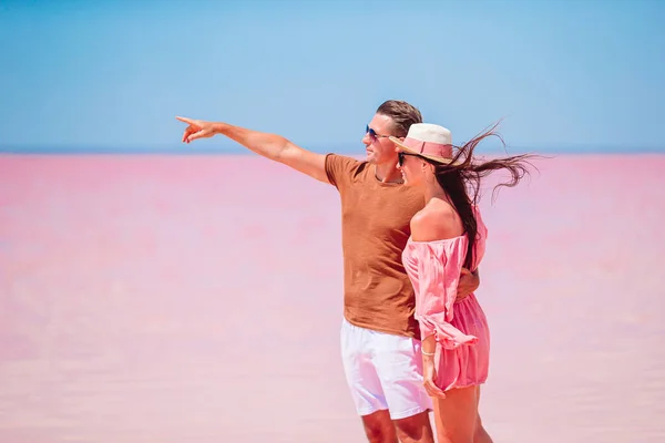 晴れた夏の日にピンクの塩湖を家族で歩く. — ストック写真