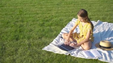 Parkta bilgisayar başında küçük bir kız.