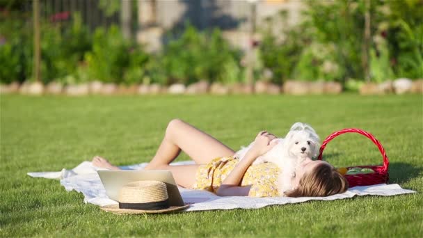 Parkta köpek yavrusuyla oynayan gülümseyen küçük kız. — Stok video