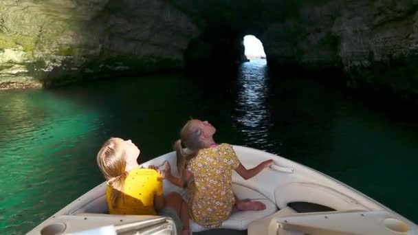 Little girls explore the cave by boat — Stock Video